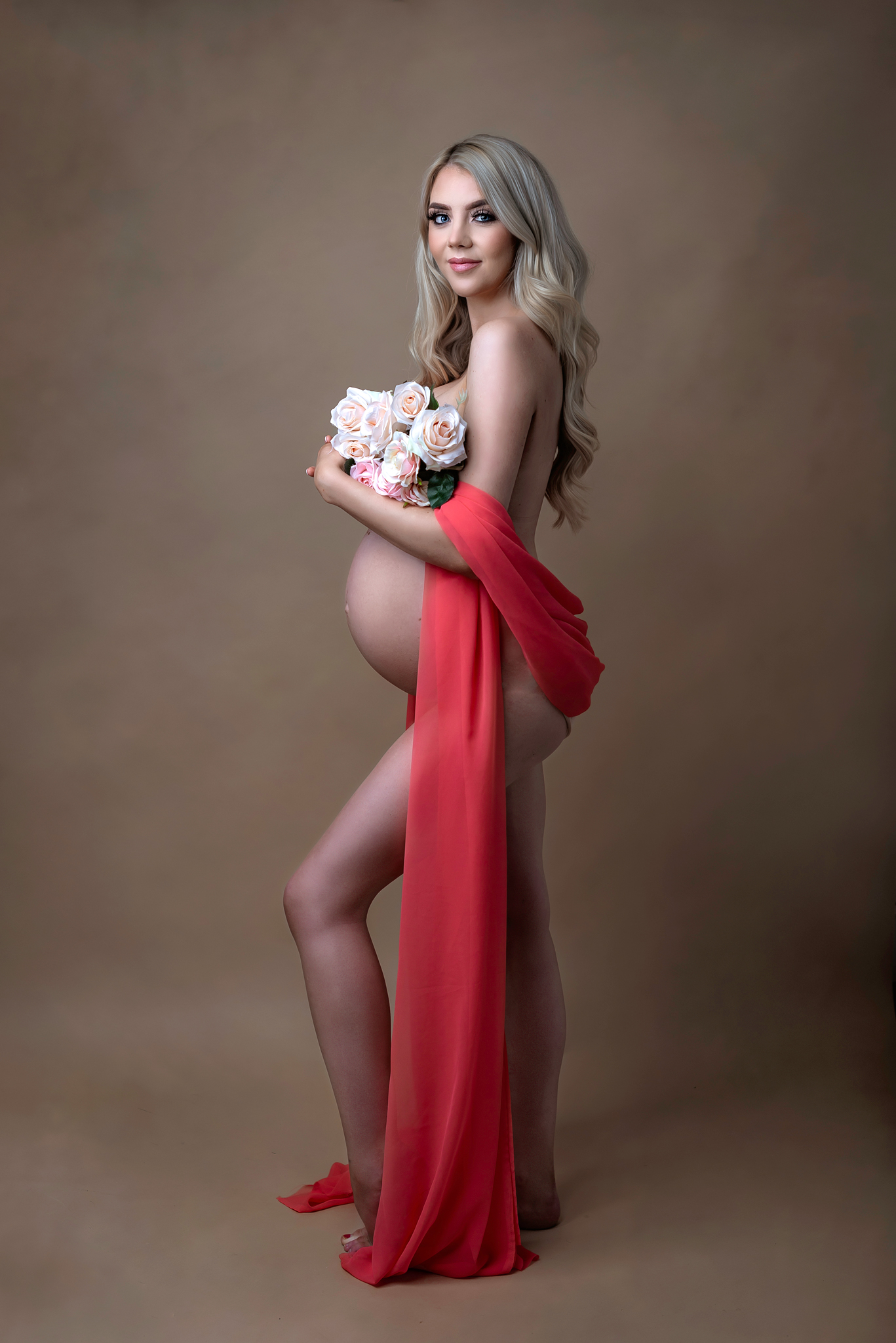 Fashion-inspired maternity portrait with red draping