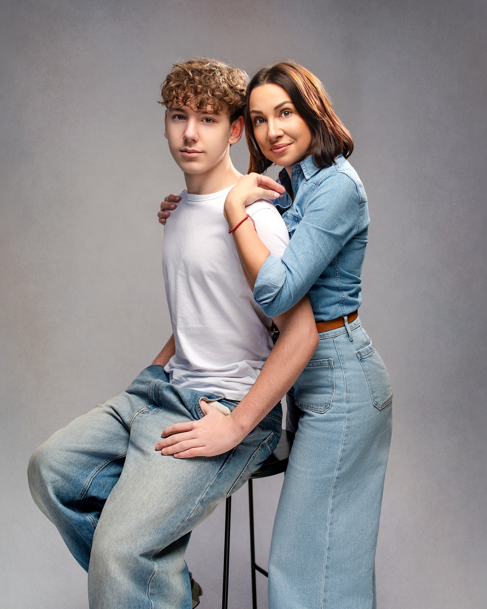 Mother and teenage son in a relaxed studio portrait