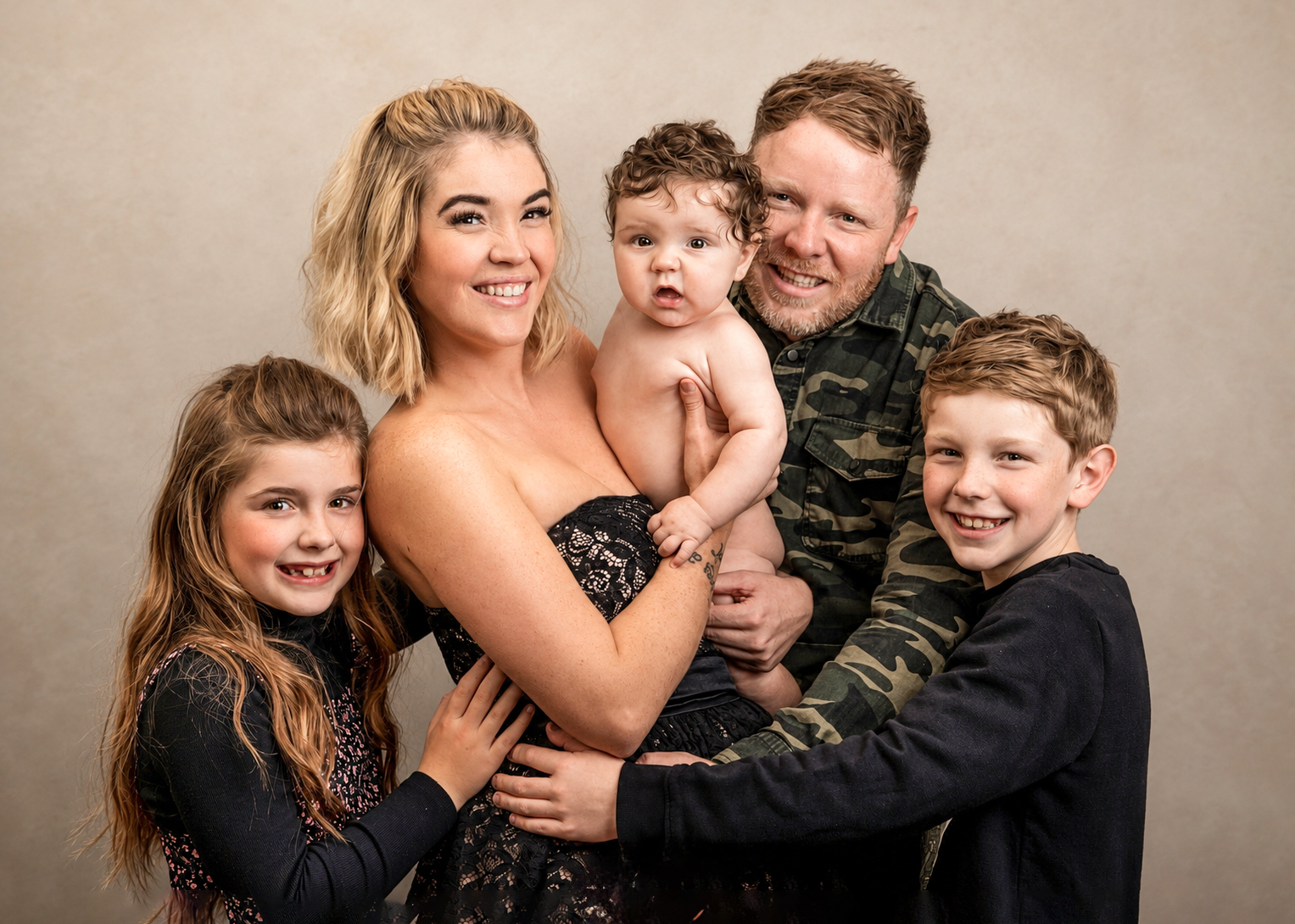 Fun studio family portrait with parents and three children