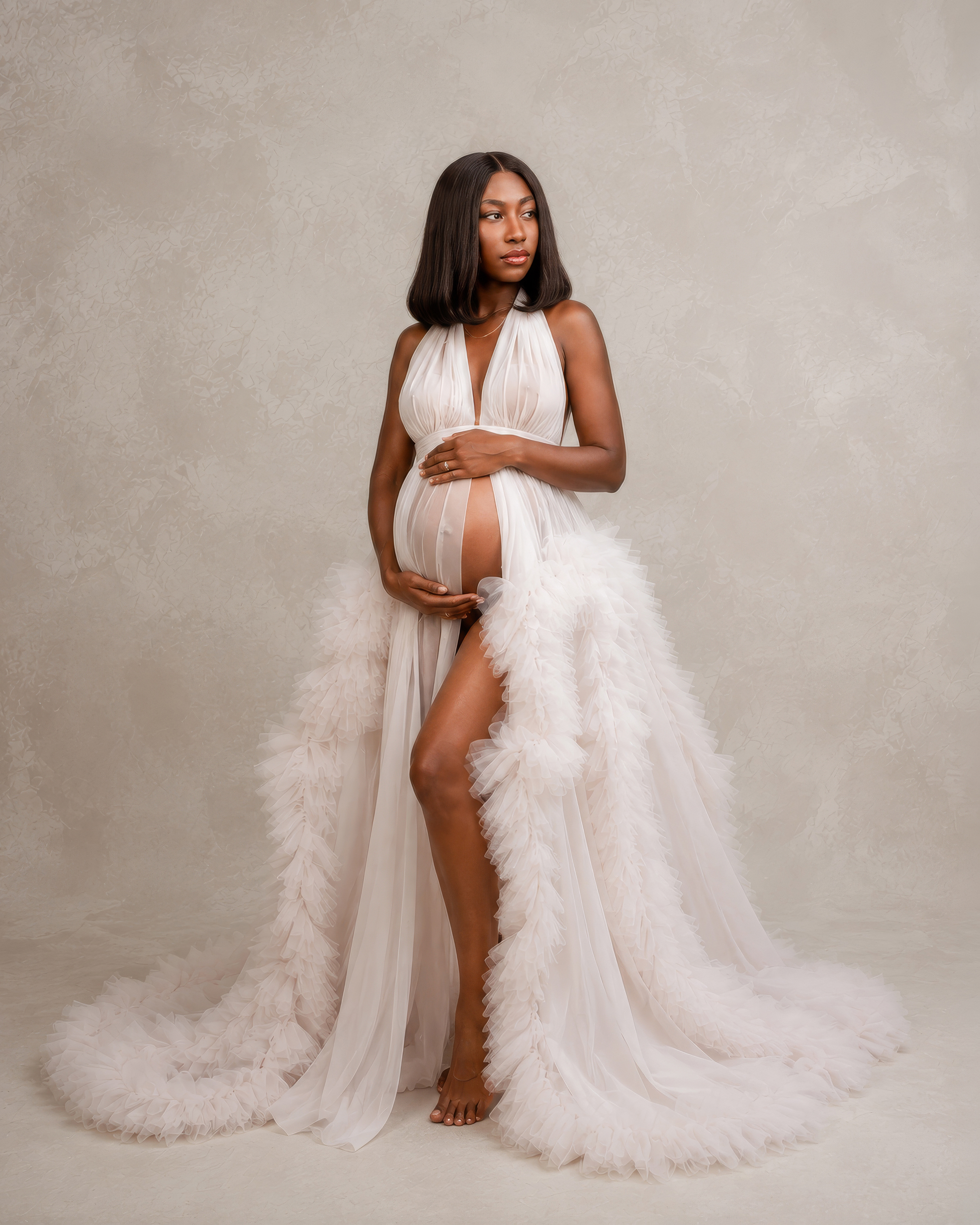 Studio maternity portrait in an elegant white tulle gown