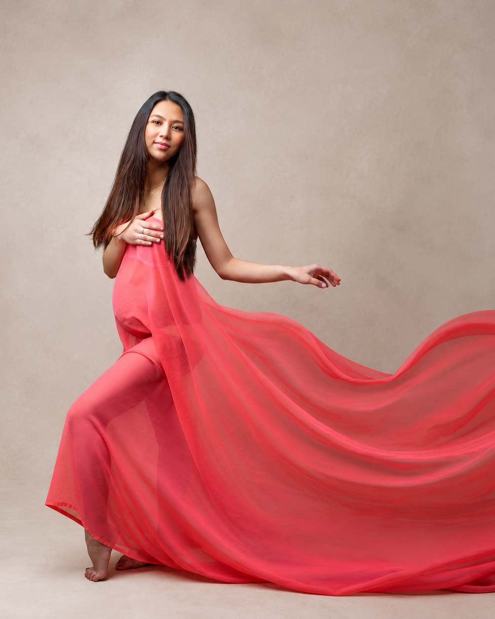 Maternity portrait with flowing coral fabric