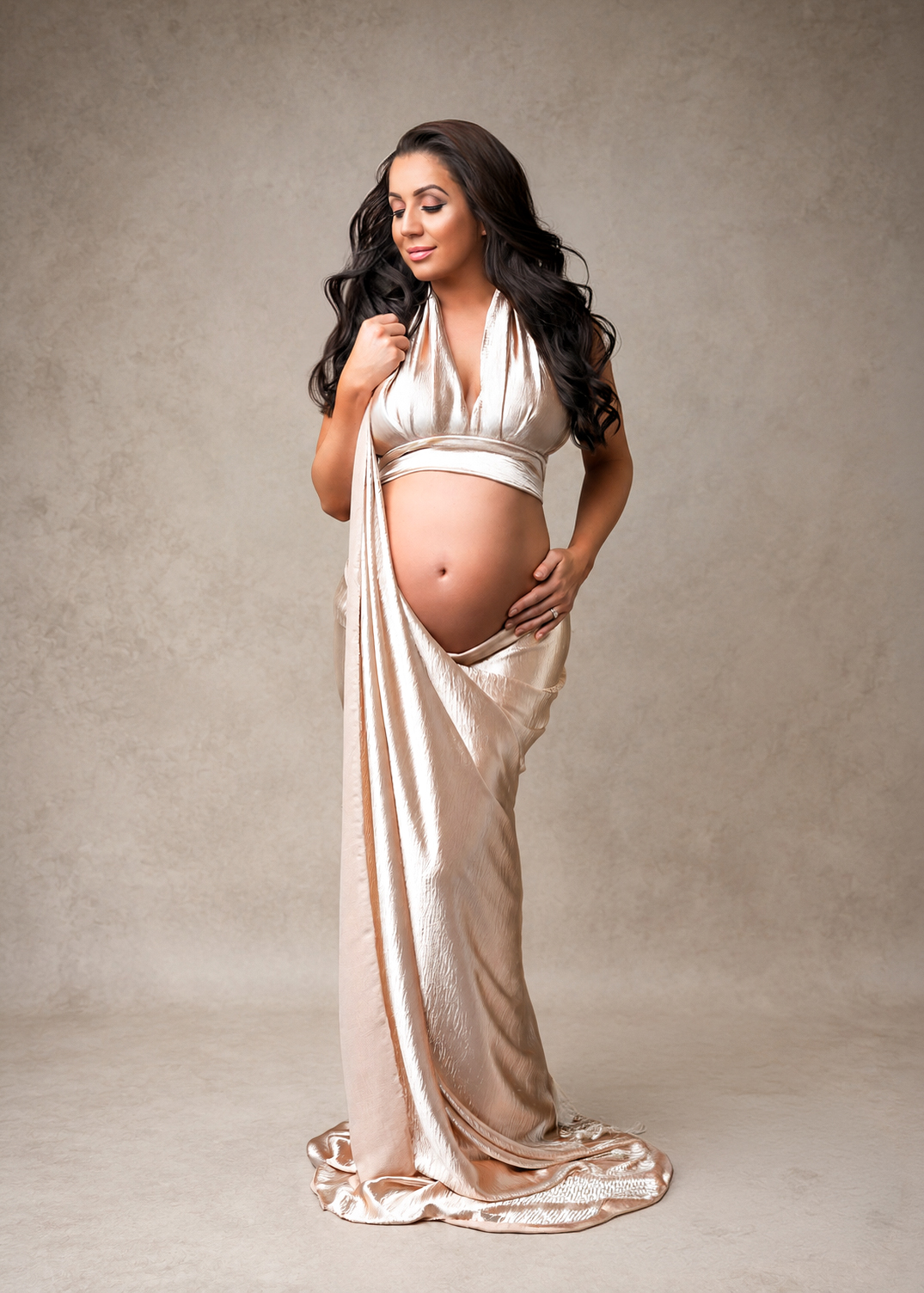 Studio maternity portrait in a champagne draped gown