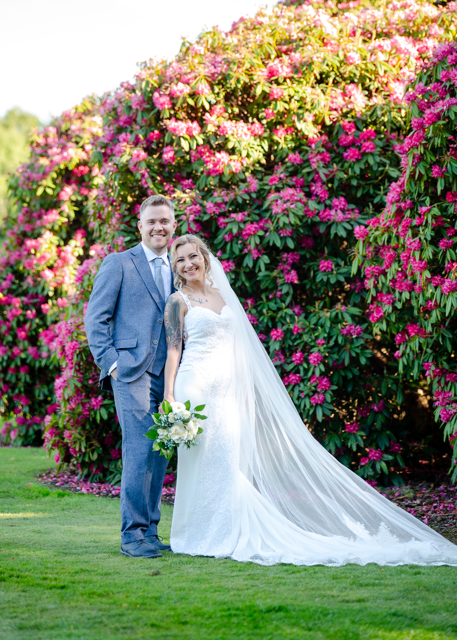 Bride and groom wedding portrait in front of flowering gardens