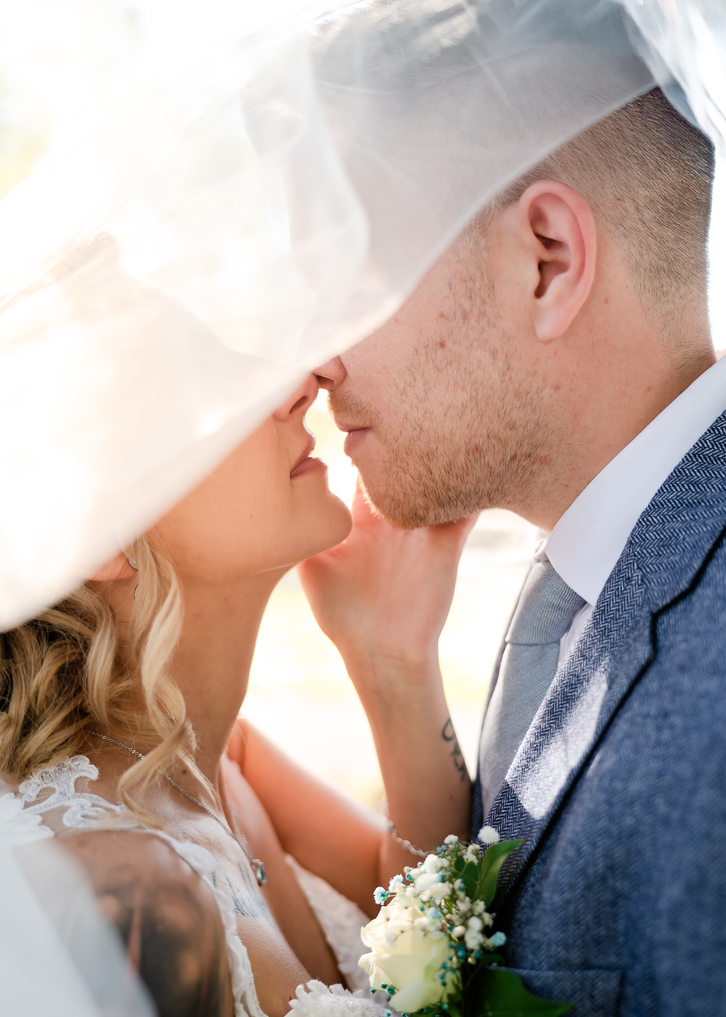 Romantic close-up of bride and groom beneath the bridal veil